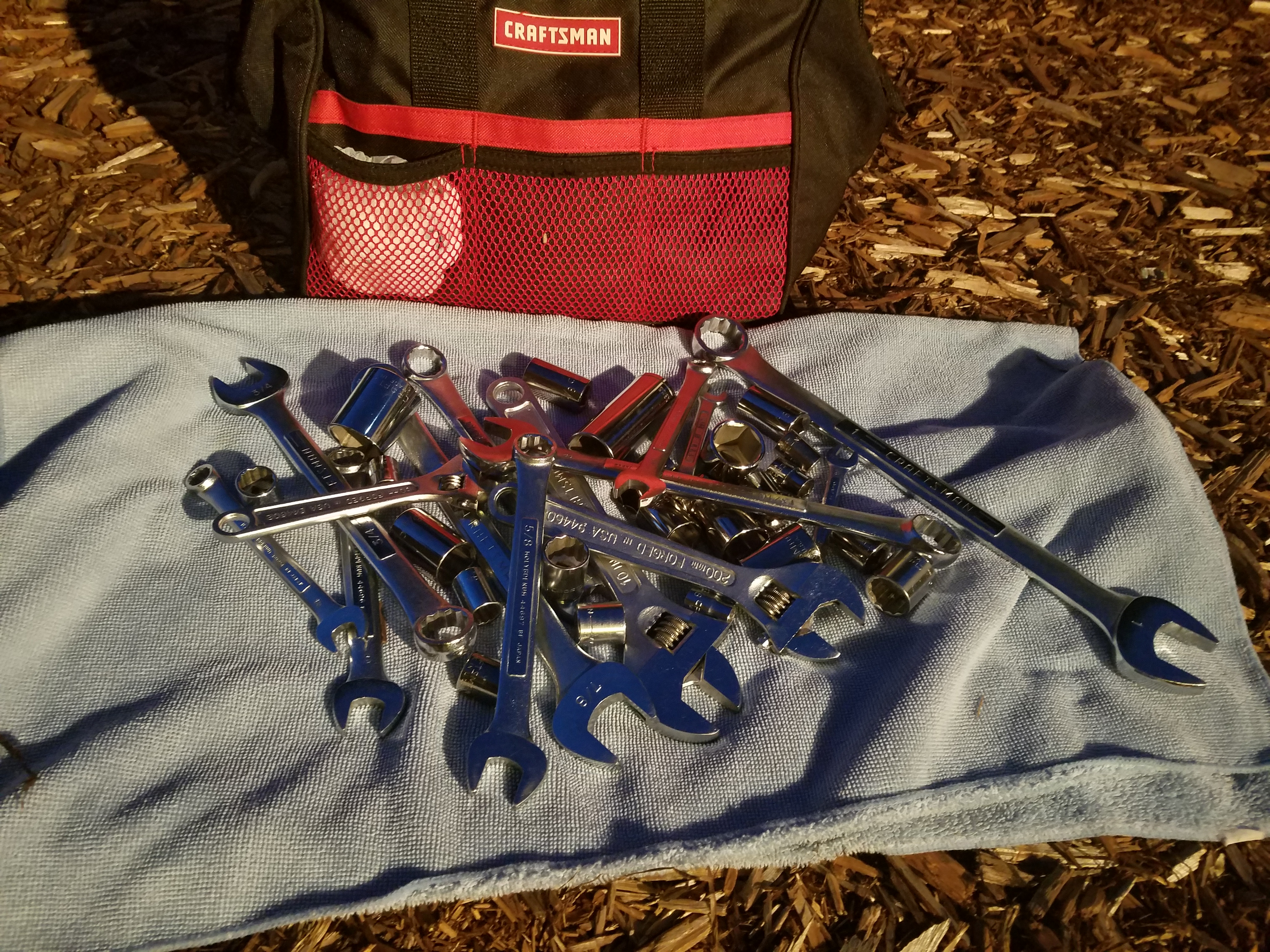 Hack - Carry a small towel in your tool bag and dump and dump tools onto it.  The towel keeps the tools from getting lost in the dirt.  A dark towel makes it easier to see your tools.