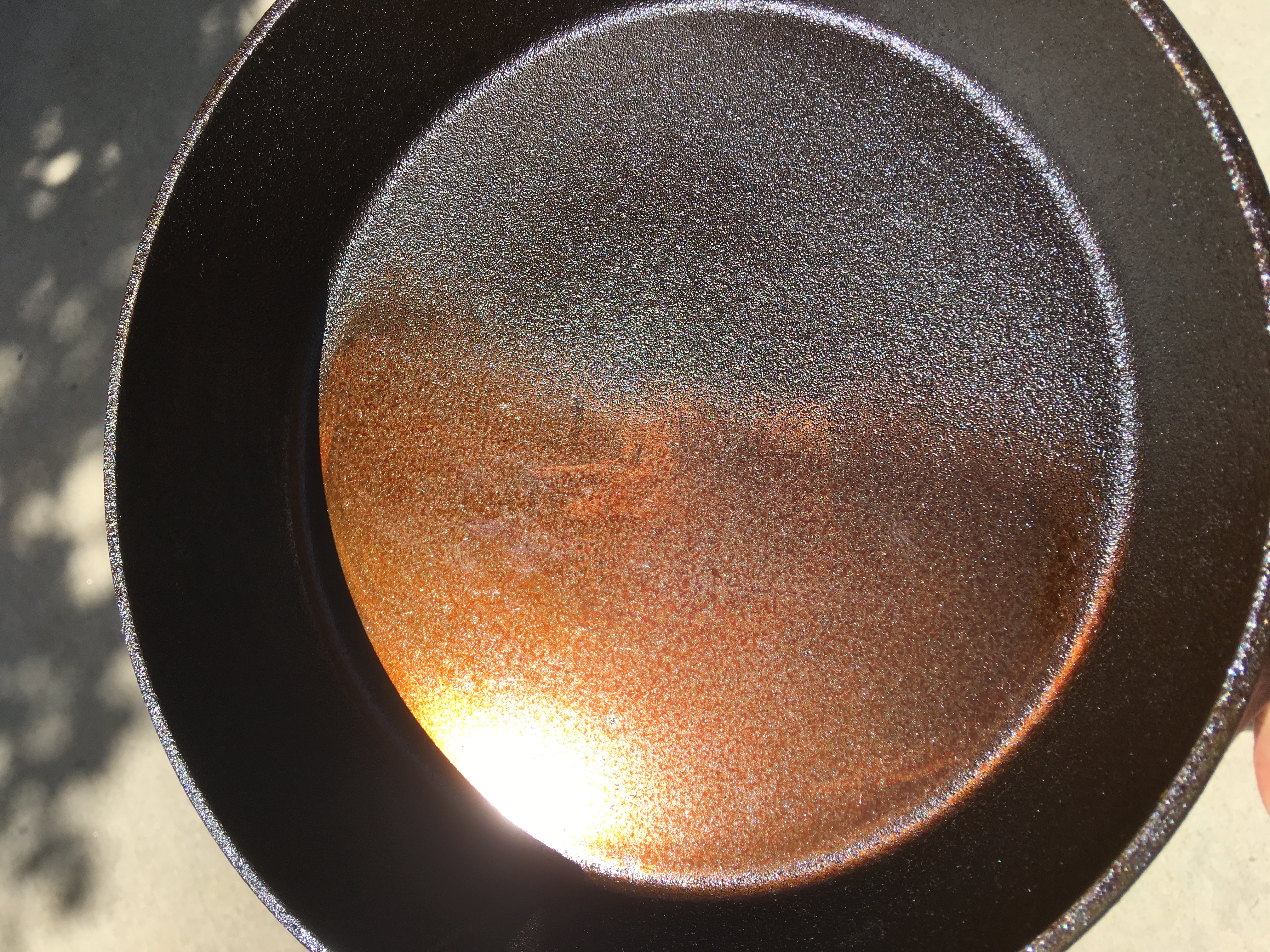 I sanded down one side of an inexpensive cast iron skillet with 60-180 grit sandpaper on a random orbit sander. Then I seasoned it with 5 coats of Food Grade Flax Seed Oil.