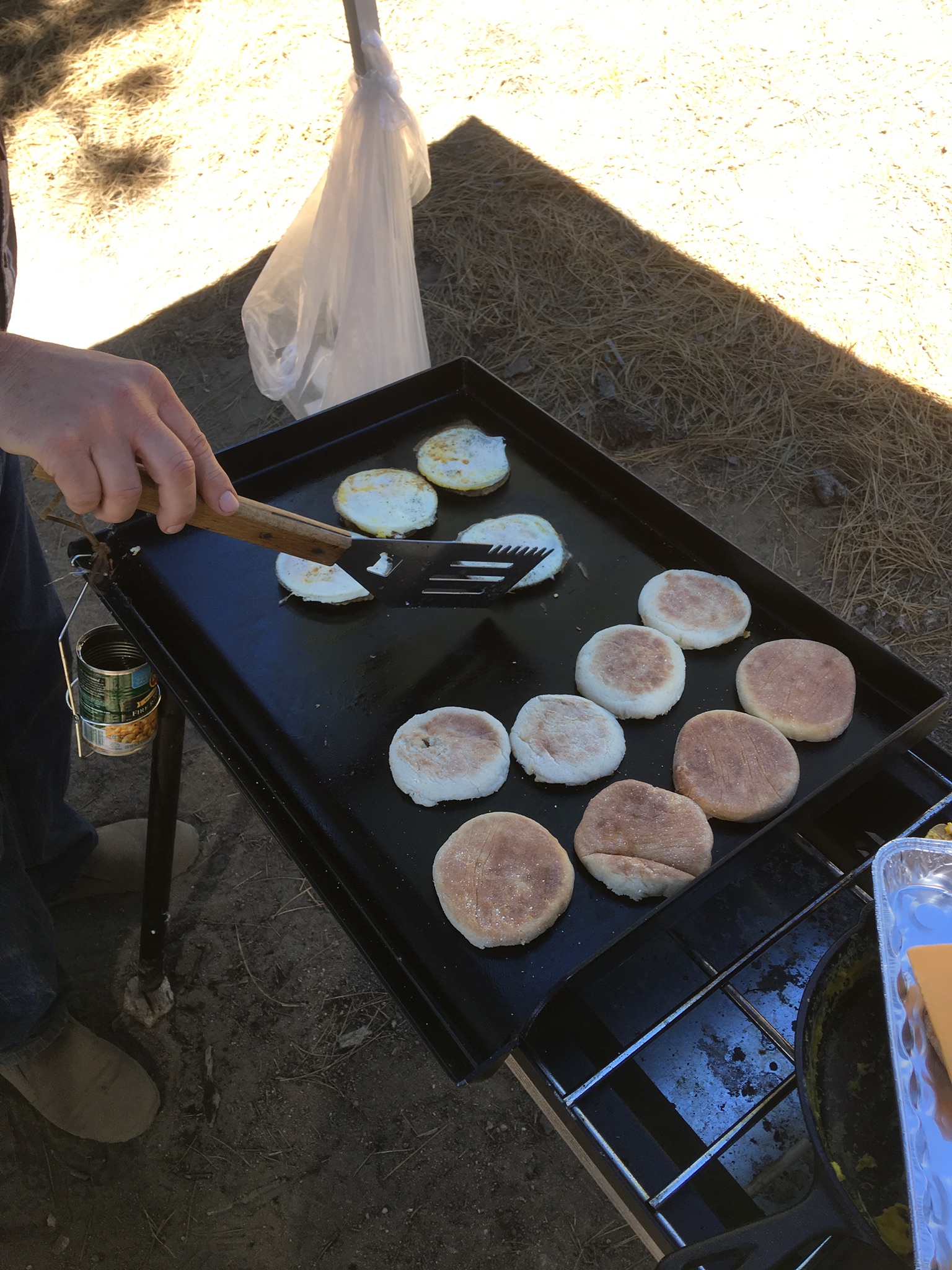 Group cooking on a three burner stove with 2 burner griddle.