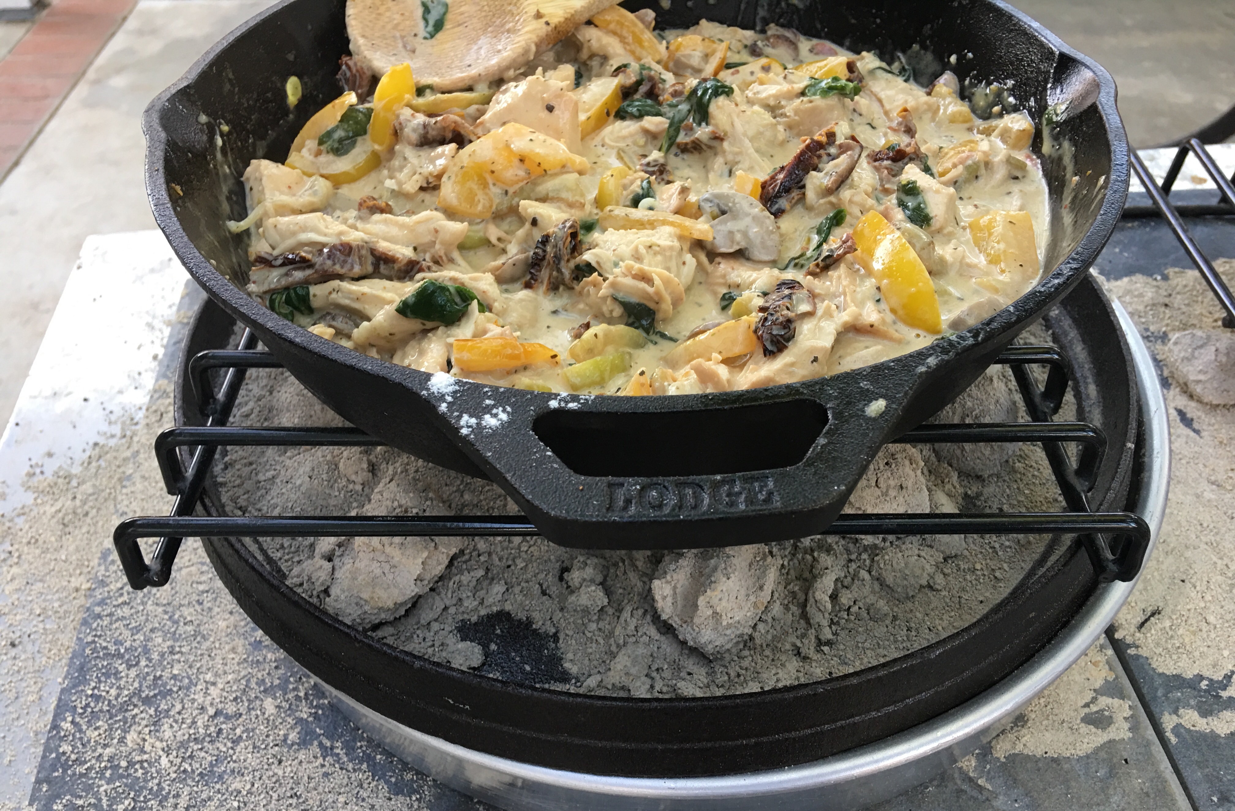 Tuscan Chicken cooked in a cast iron skillet on top of Dutch oven brownies