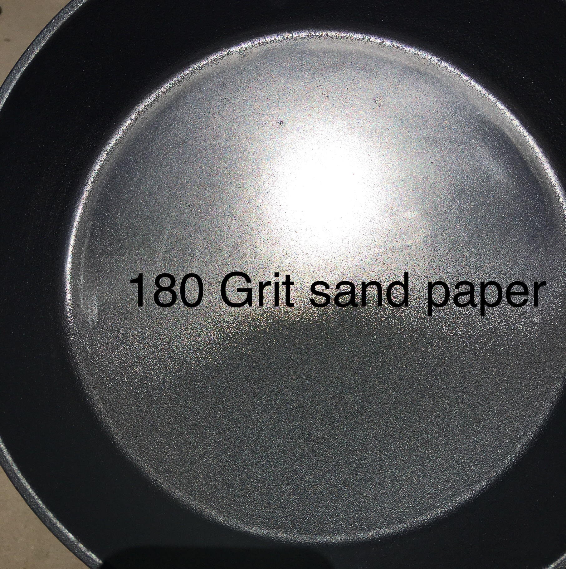 A light sanding with 60-180 grit paper or flap wheel will provide a much better surface without requiring many years of use to raise the seasoning above the high points of the pans surface. Rough surface provide more points of contact with the food.