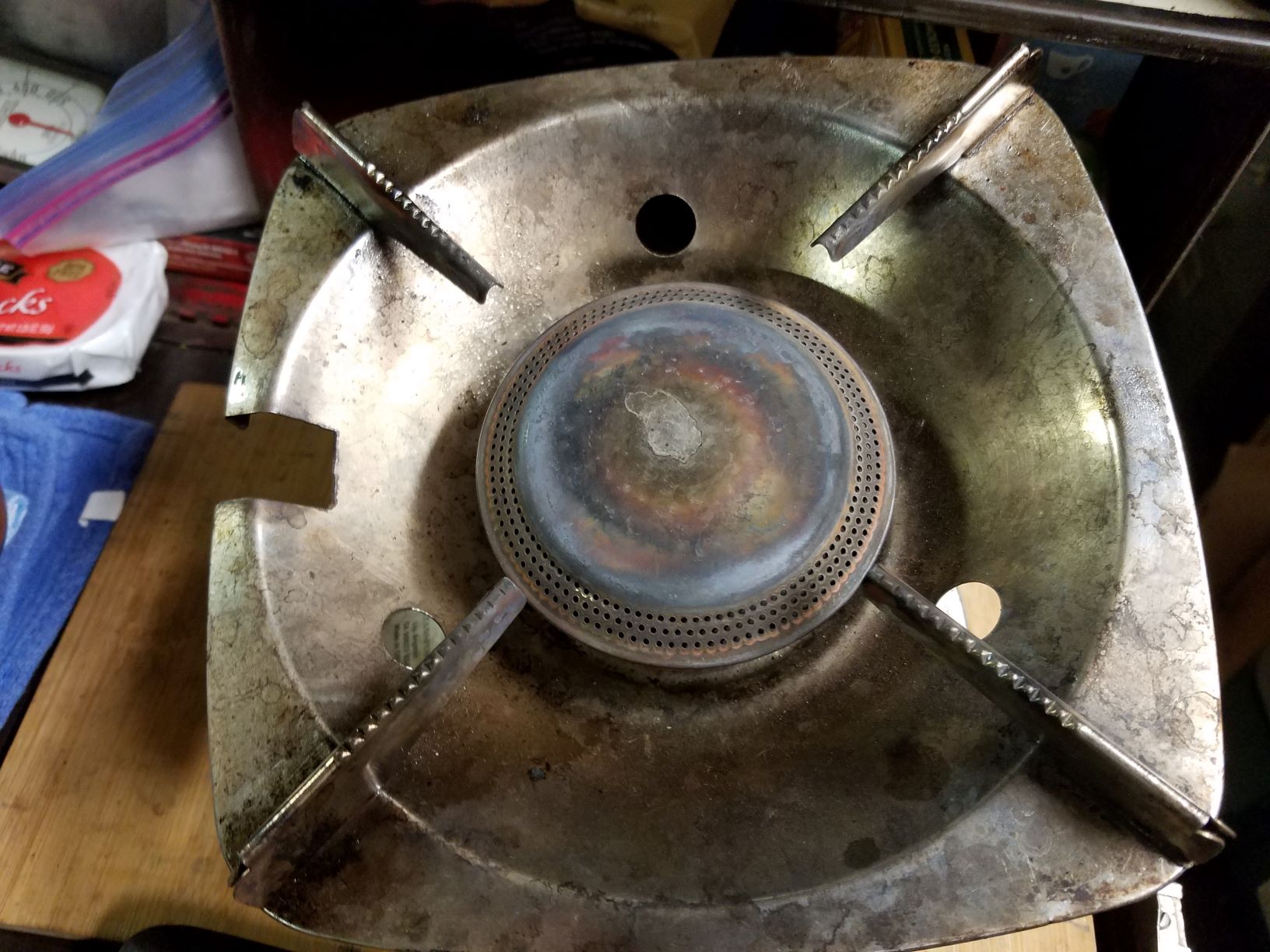 Single burner stove with notch for 3rd leg of Dutch Oven travels in box.jpg
