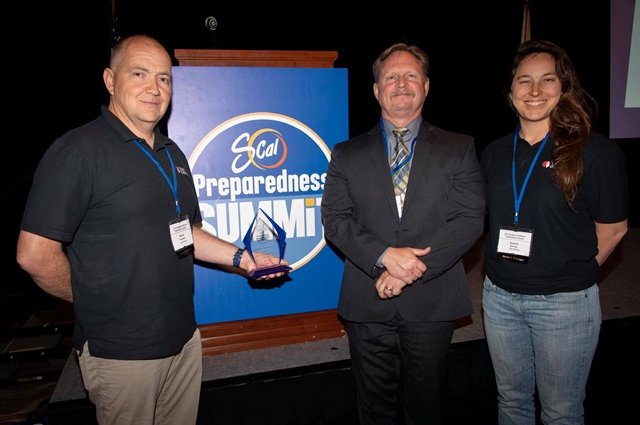Kevin Kothlow from Team Rubicon, EMD Director Bruce Barton and Team Rubicon’s Emma Strong with the Community Service Award given at the SoCal Preparedness Summit.