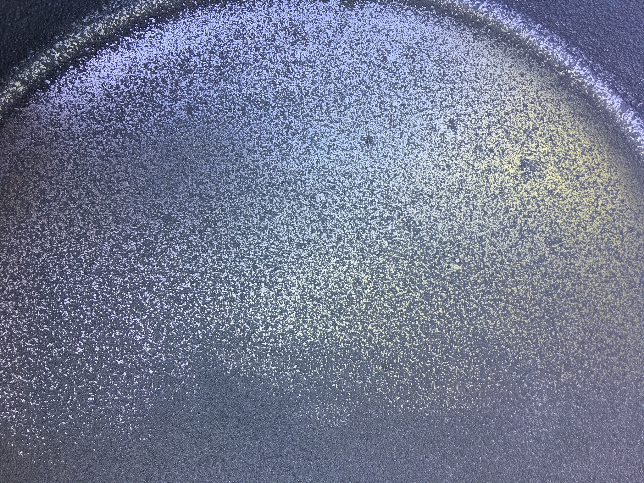 Even taking the high spots or roughness out of the pan will give you a much better cooking surface. 80-100 grit sandpaper will be fine.