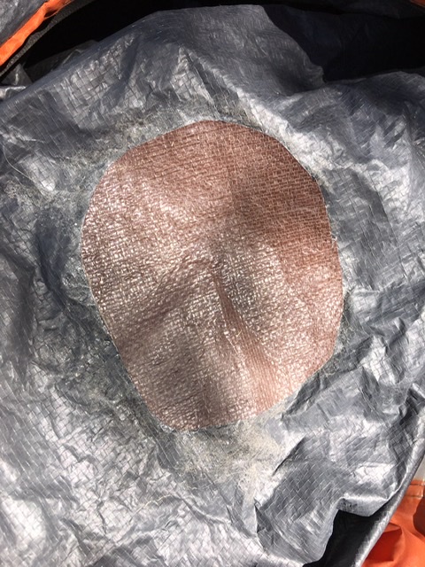 Patch was made from an old tarp and applied using a solvent based spray adhesive( contact cement). Works like a champ.