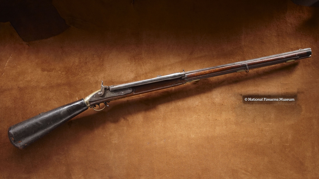 This 22-shot repeating air rifle is an original Girardoni military pattern rifle of the type used on the Lewis &amp; Clark Expedition. It is a butt reservoir piece with a bore size of .462 caliber. Similar pieces were supplied by Bartolomeo Girardoni to the Austrian army circa 1780. As originally issued, each Girardoni air rifle had three detachable air reservoirs, each requiring about 1,500 strokes of a pump to completely pressurize the reservoir. Once filled to operating pressure (about 800 psi) the air rifle could fire up to 70 shots before the reservoir required replacing. A metal tube on the side of the barrel held up to 22 lead balls that could be fed one at a time to the firing chamber by a simple sideways push of a plunger. At a distance of 50 feet, this rifle is capable of placing ten shots into a group the size of a quarter.<br /><br />http://www.nramuseum.org/guns/the-galleries/a-prospering-new-republic-1780-to-1860/case-8-romance-of-the-long-rifle/girardoni-air-rifle-as-used-by-lewis-and-clark.aspx<br /><br />Loaned by Michael F. Carrick