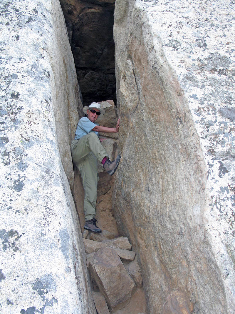 Climb up this slot on the north side and then climb out an opening at the far end of a tunnel to reach the top.