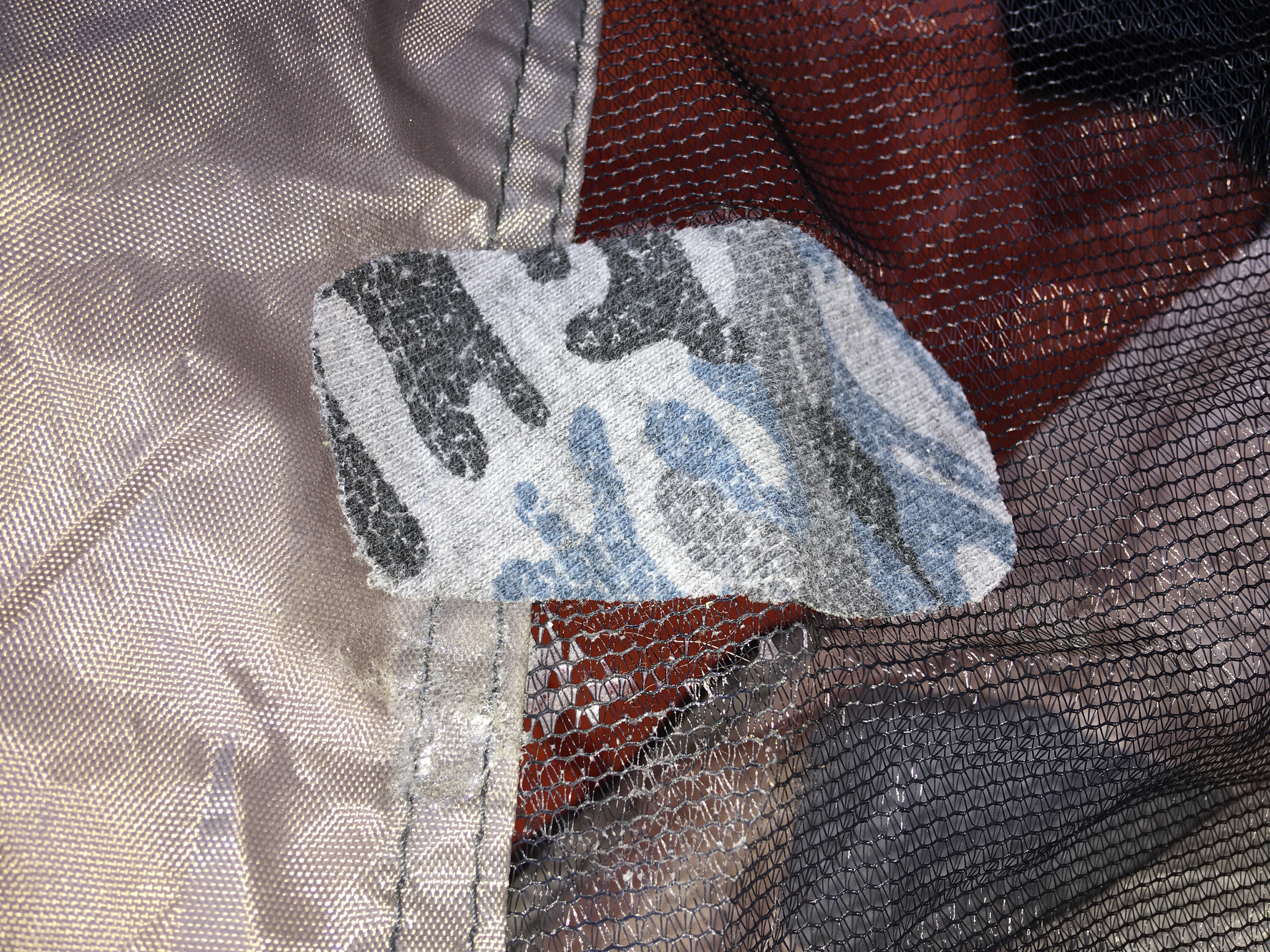 Most any material can be used to make an emergency repair with solvent based adhesives. No more bugs in the tent.